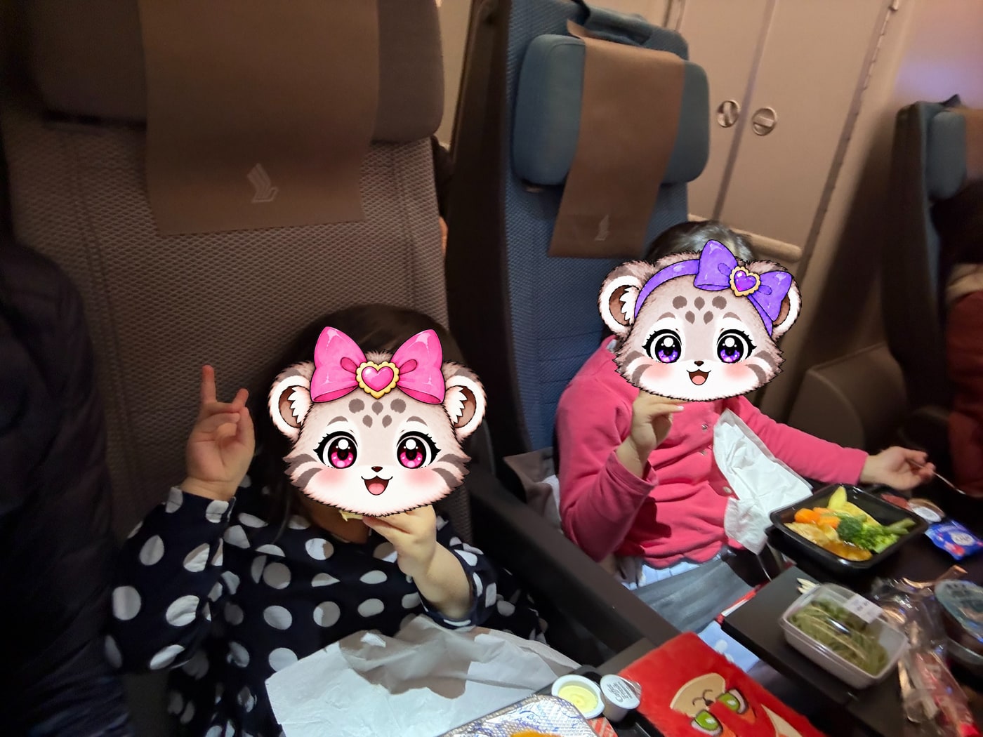 シンガポール航空の機内で。2人とも機内食をおいしそうに食べていました。
