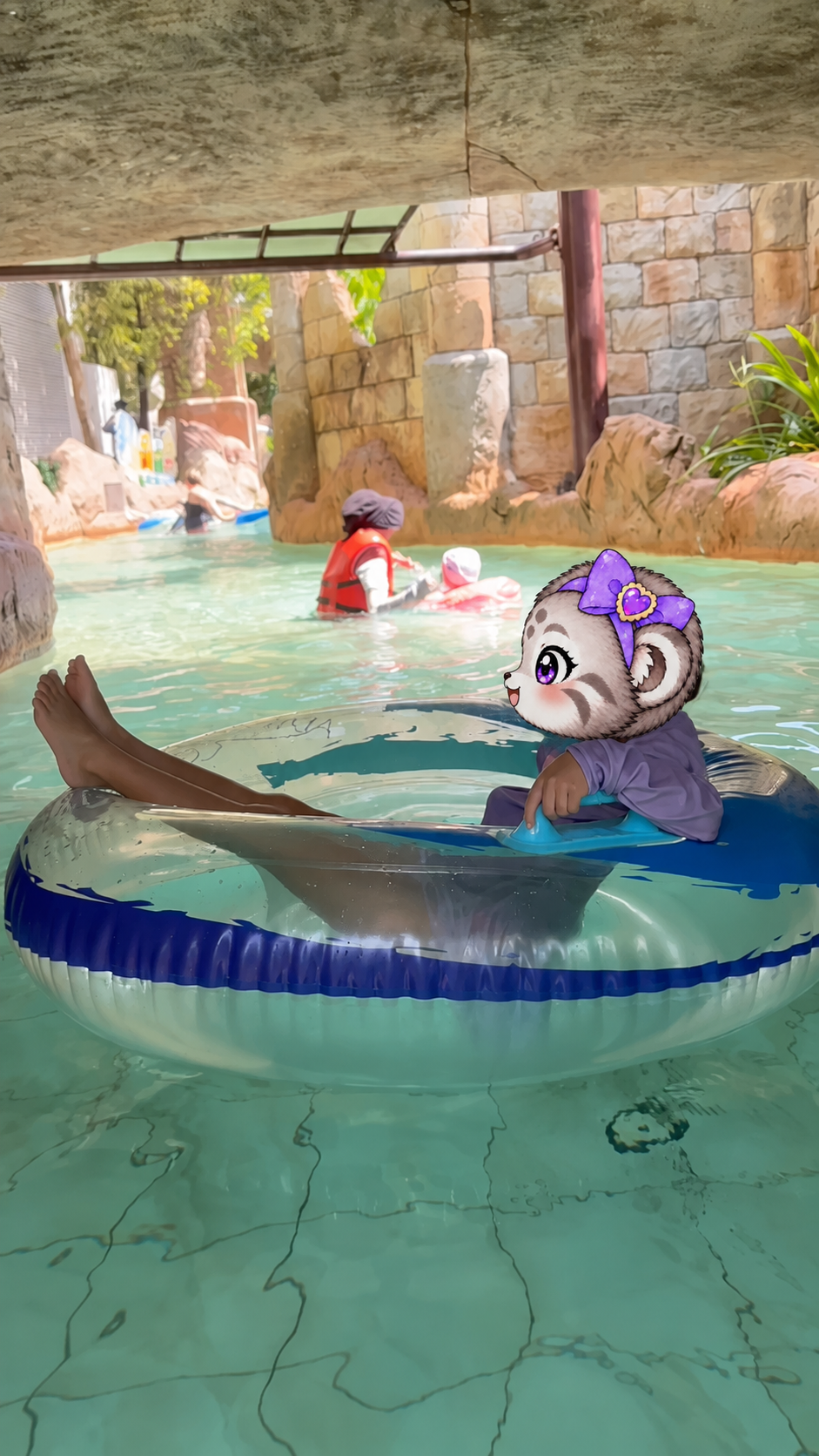 大きな浮き輪に乗って流れるプールを進むこまぬ