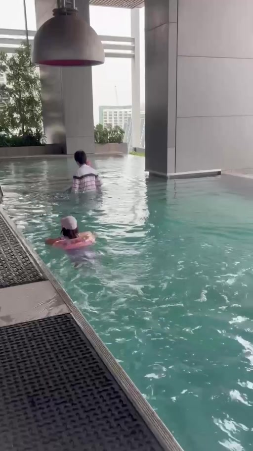 プールで遊ぶ家族の後ろ姿