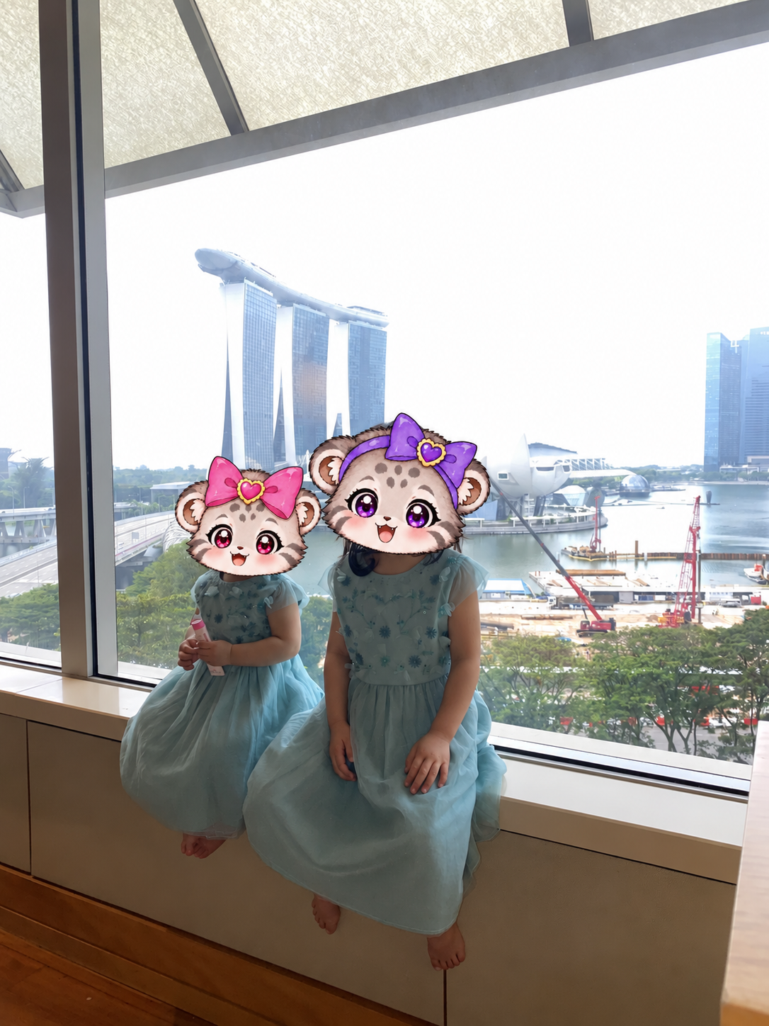 青いお揃いドレスで窓辺に座るこみぬとこまぬ。顔はキャラクターで保護